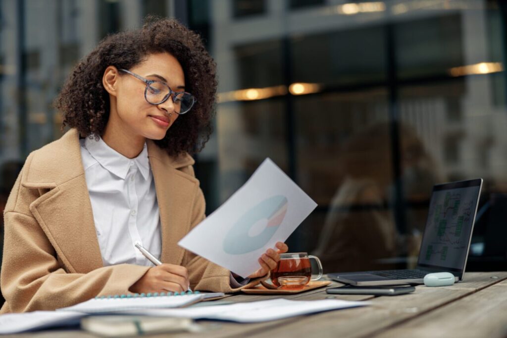 female professional using laptop at desk with documents